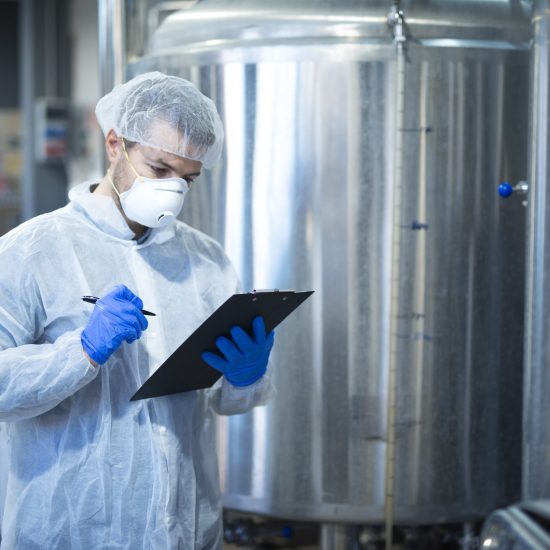 Technologist expert controlling production in pharmaceutical or food processing factory.