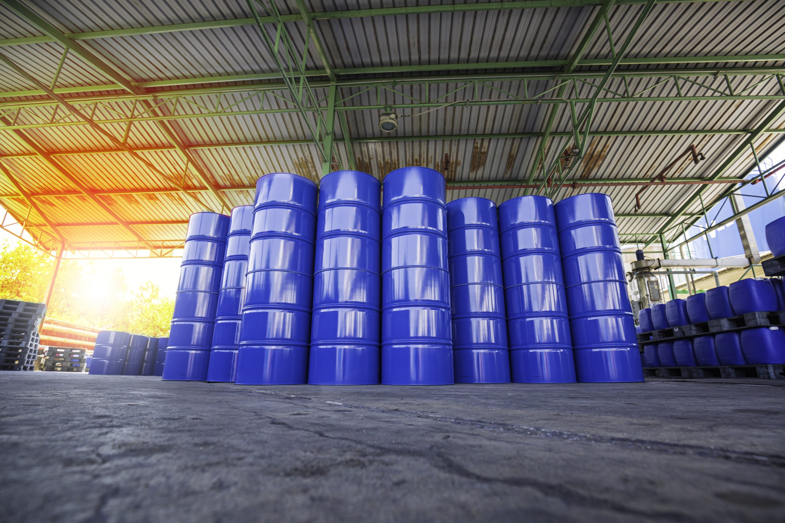 Oil barrels blue or chemical drums vertical stacked up sun light orange